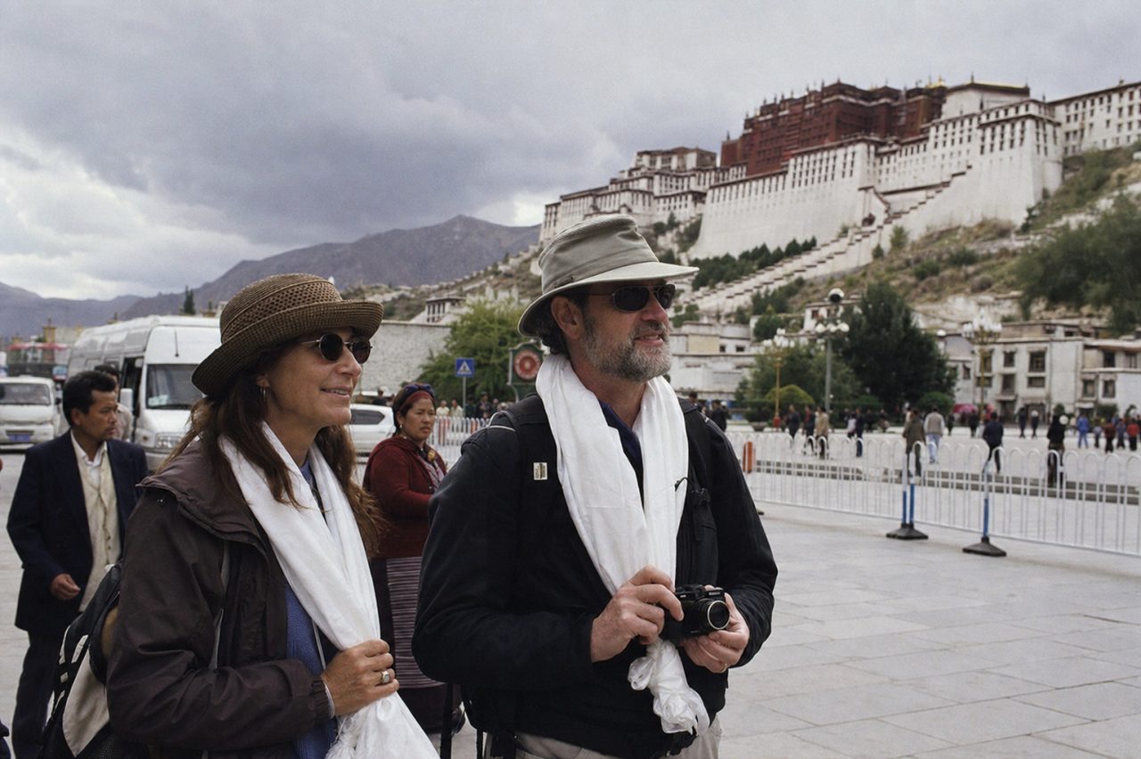 American travelers arriving in Lhasa with the Potala Palace visible in the background