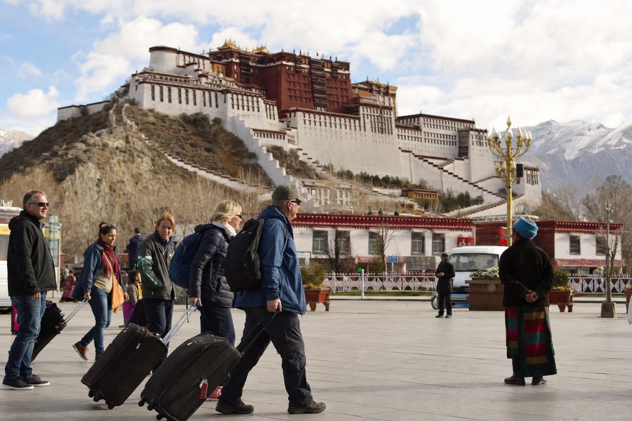 American travelers beginning a Tibet tour in Lhasa with the Potala Palace visible in the background