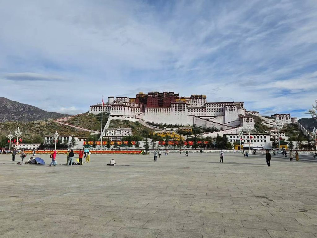 Traveler photo moment near Potala Palace in Lhasa with the palace in the background